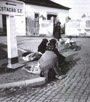 Mulheres sentadas no lancil do passeio  espera da camioneta.