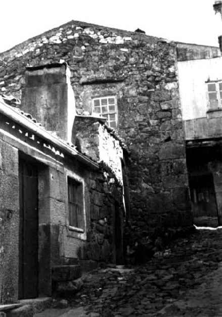 Rua da aldeia na Beira Alta - estreita, com casa em granito, janelas de guilhotina e pavimento em pedra solta de granito